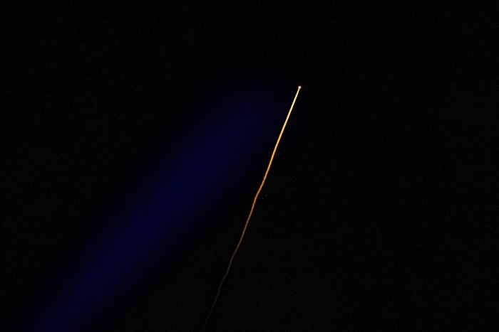 Rocket launch trail in dark sky
