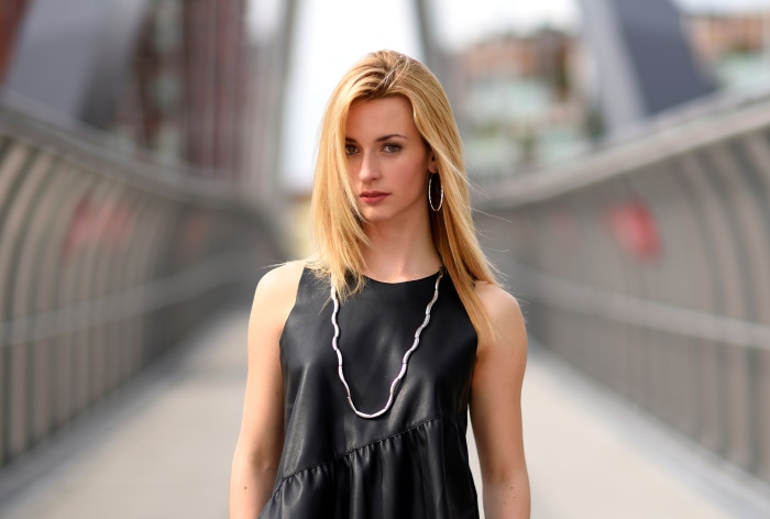 Blonde woman in black dress on a bridge