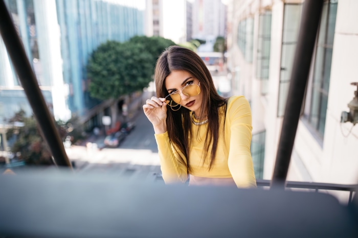Victoria Justice in yellow top and sunglasses