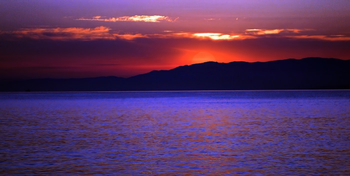 Sunset over the ocean with mountains