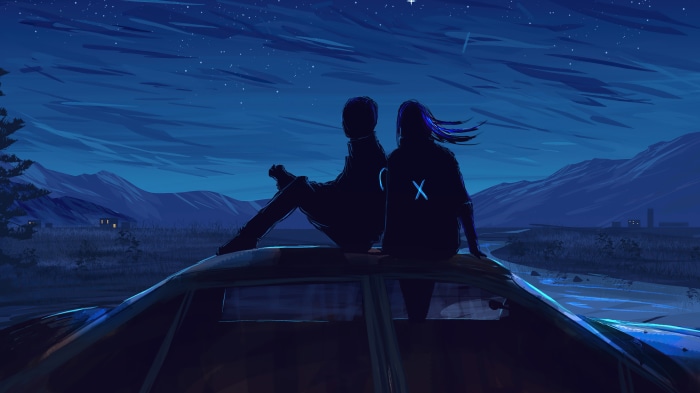 Couple sitting on a car roof at night