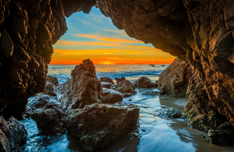 Cave entrance overlooking ocean sunset at Malibu Beach, California