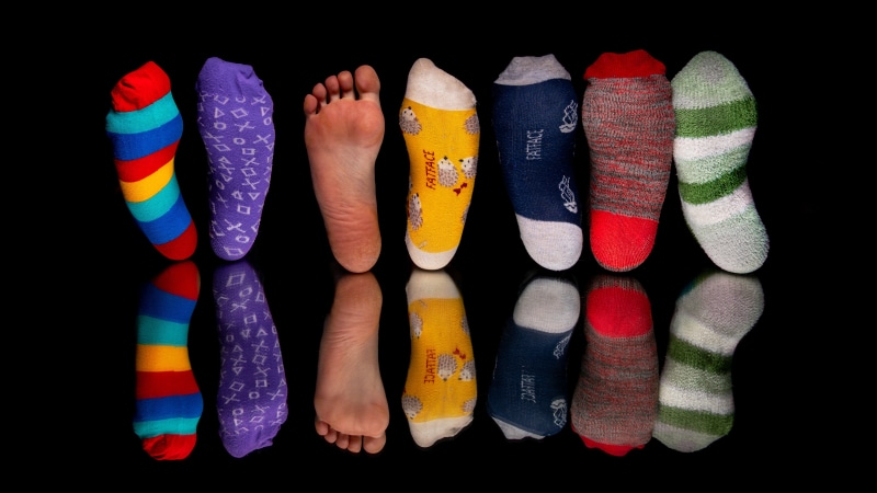Socks and feet with reflection on black background