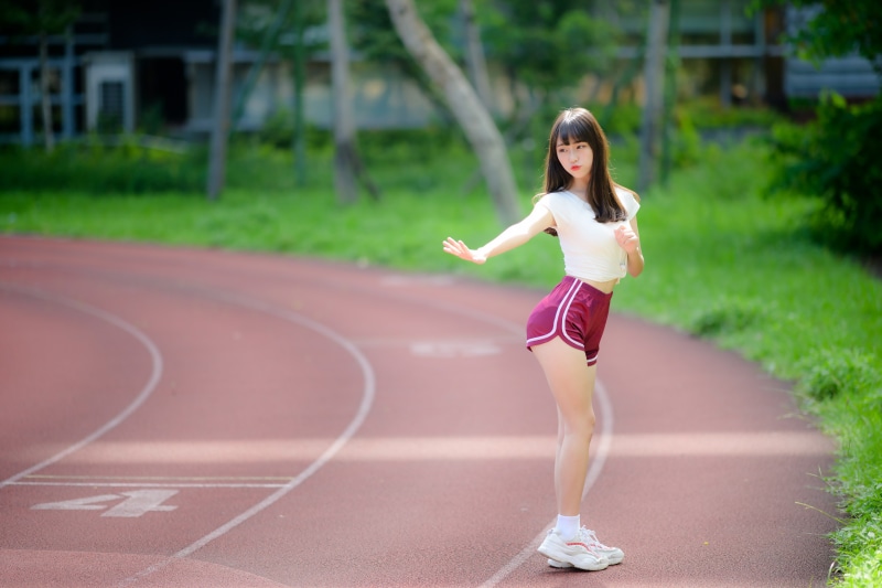Asian woman in athletic wear on a running track