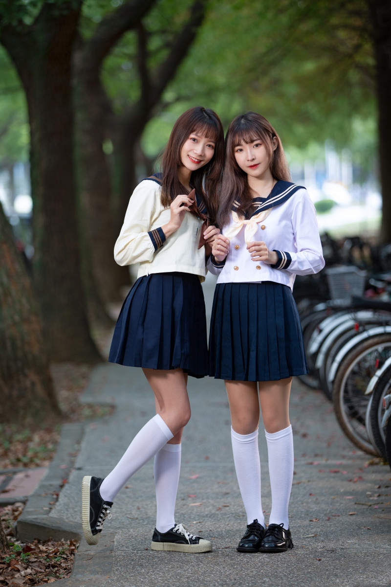 Two Asian schoolgirls in uniform smiling