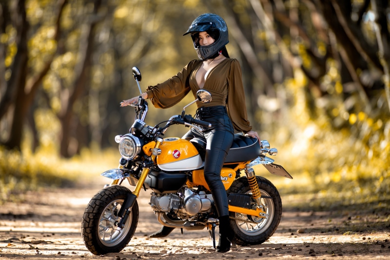 Asian woman in helmet on yellow motorcycle