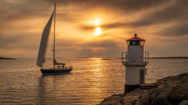 Sailboat and Lighthouse at Sunset in Timret, Sweden