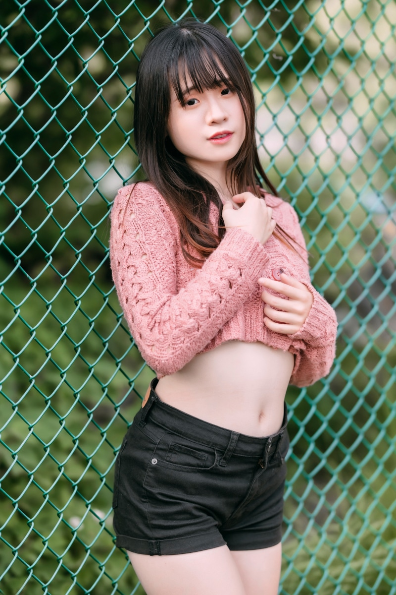 Asian girl in pink crop top and black shorts