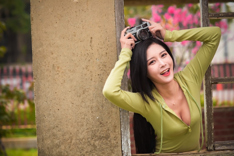 Asian woman with camera in a window
