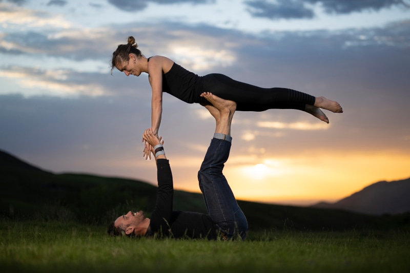Couple doing acroyoga at sunset