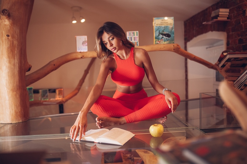 Woman in red sportswear reading a book