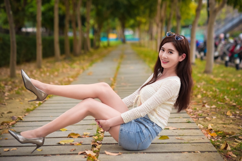 Asian woman with brown hair wearing a blouse and skirt