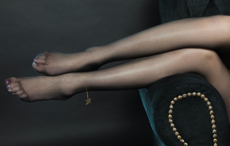 Woman's legs in pantyhose with anklet