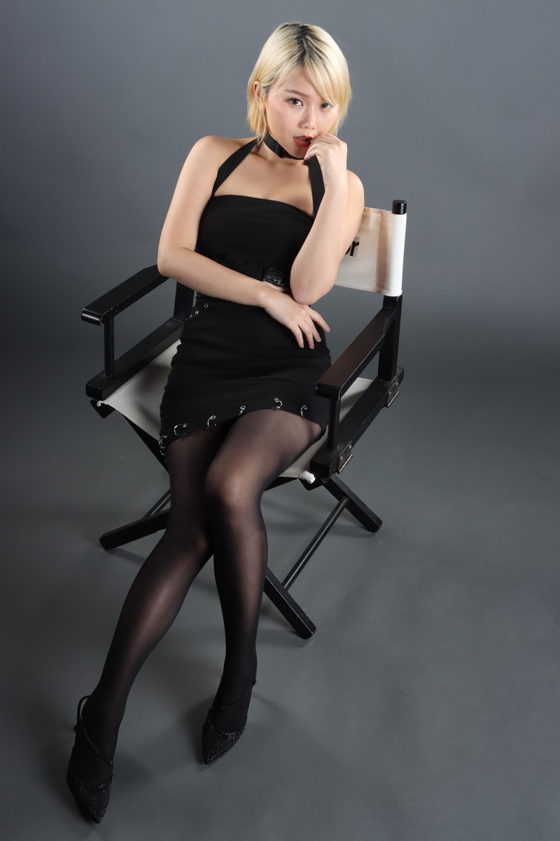 Asian woman with blonde hair sitting in a director's chair