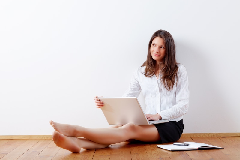 Woman with Laptop Sitting on Floor