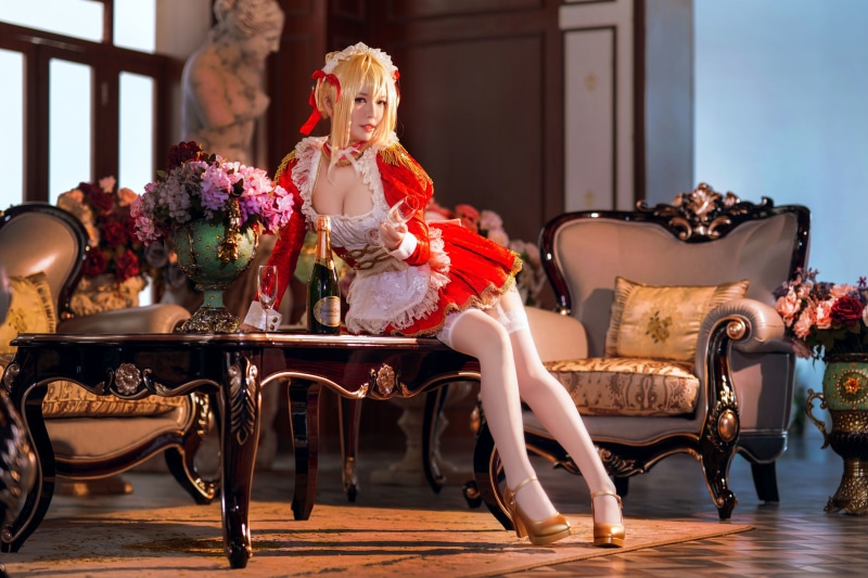 Cosplayer in a red and white maid outfit with champagne