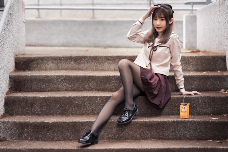 Asian girl in school uniform sitting on stairs