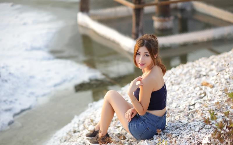 Asian woman sitting by the water