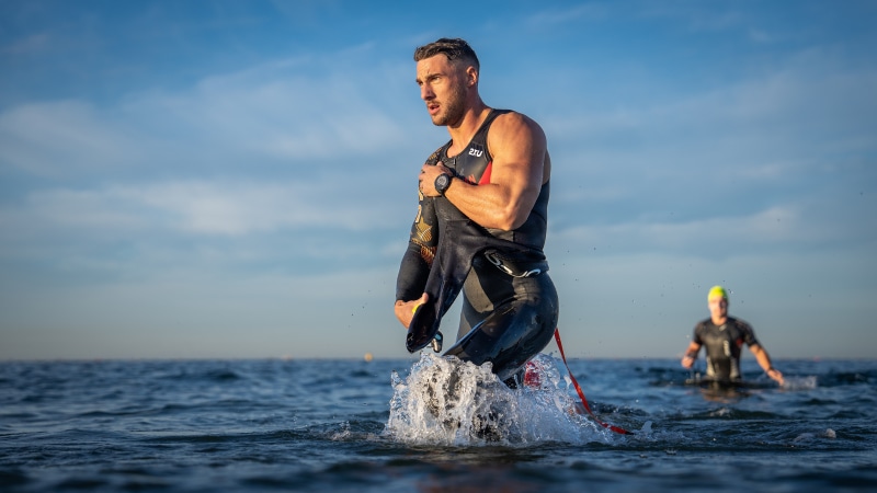 Man in wetsuit emerging from water