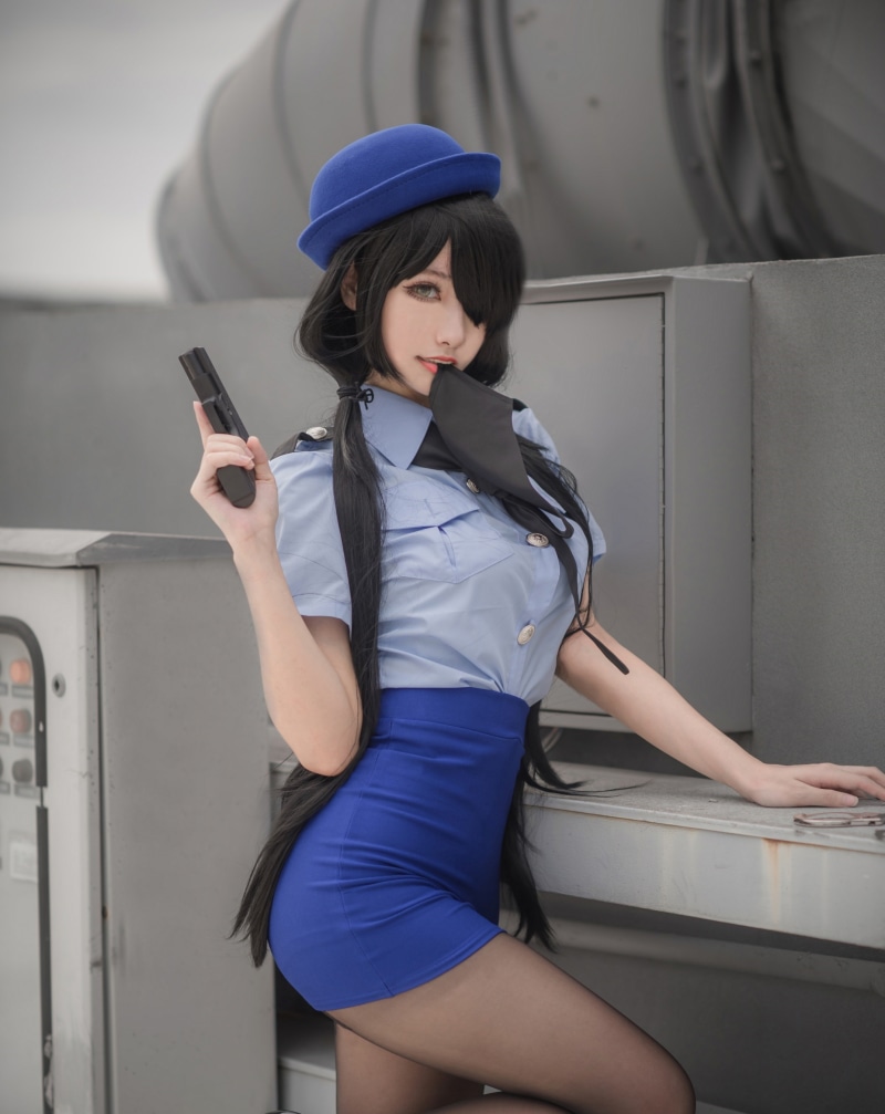 Woman in police uniform holding a pistol