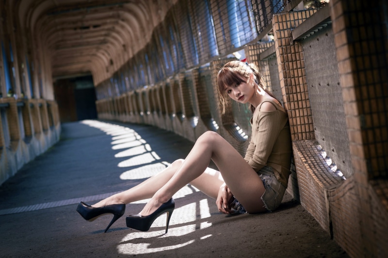 Asian woman with brown hair sitting in a tunnel