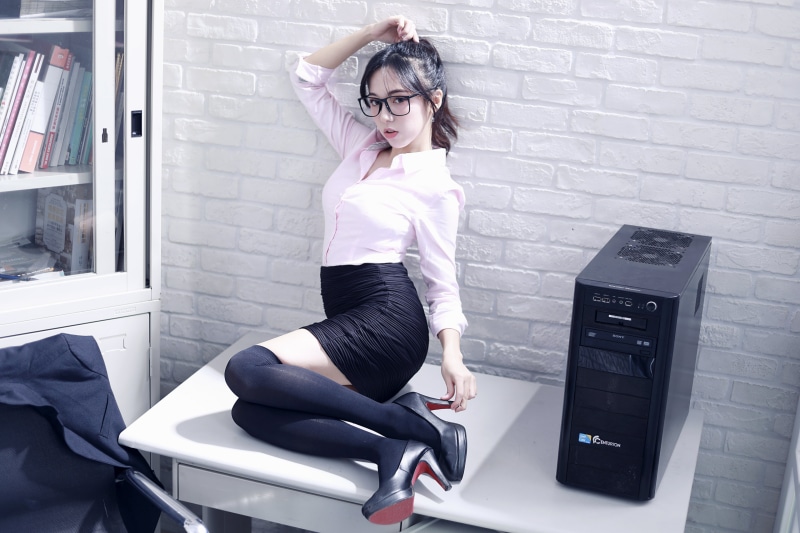 Asian woman in glasses posing on a desk
