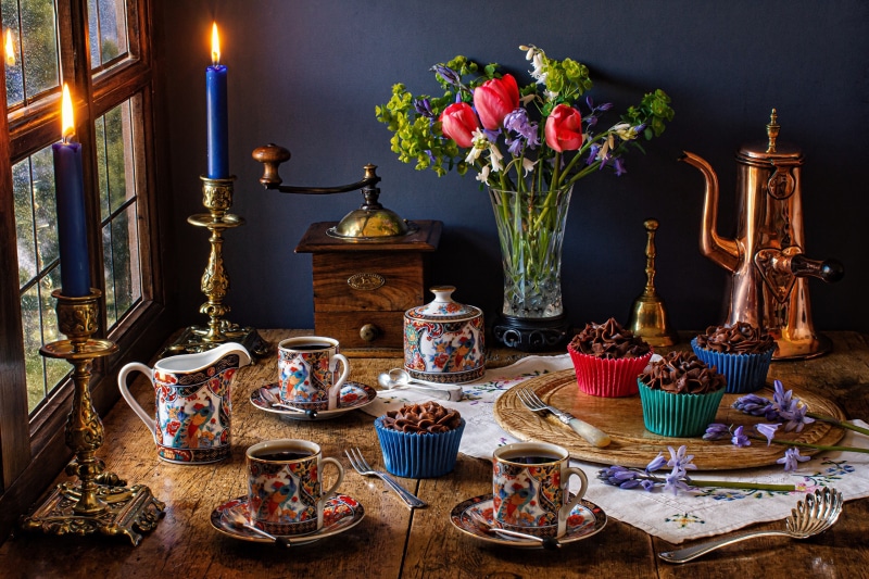Still life with coffee, cupcakes, and flowers