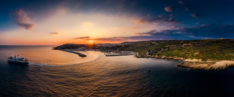 Ferry sailing near Gozo, Malta at sunset
