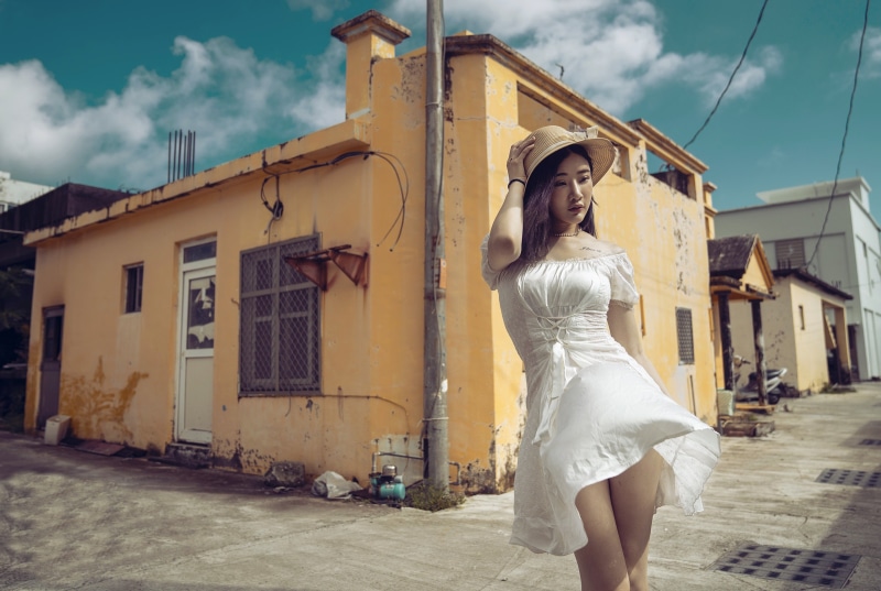 Asian woman in white dress and hat