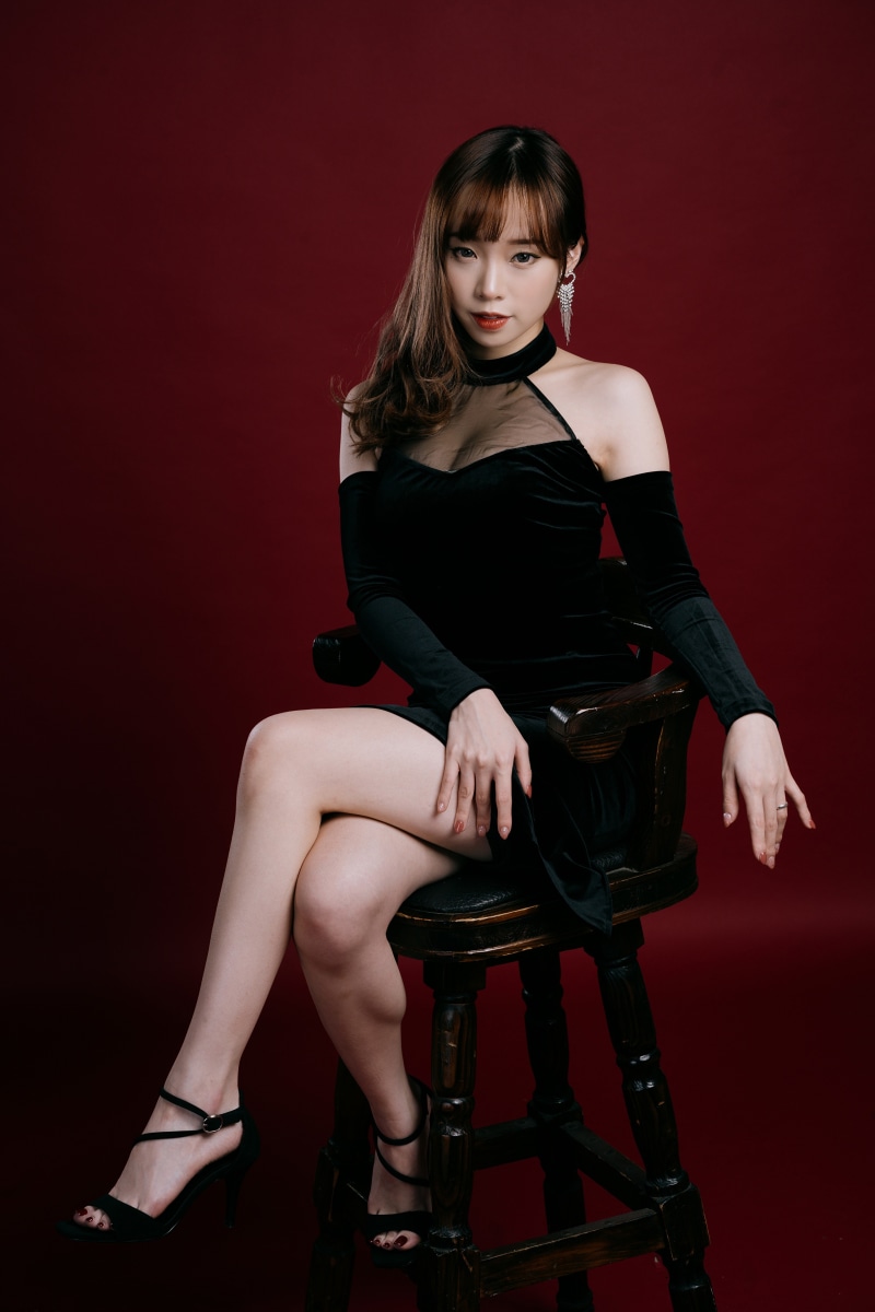 Woman in black dress sitting on a chair