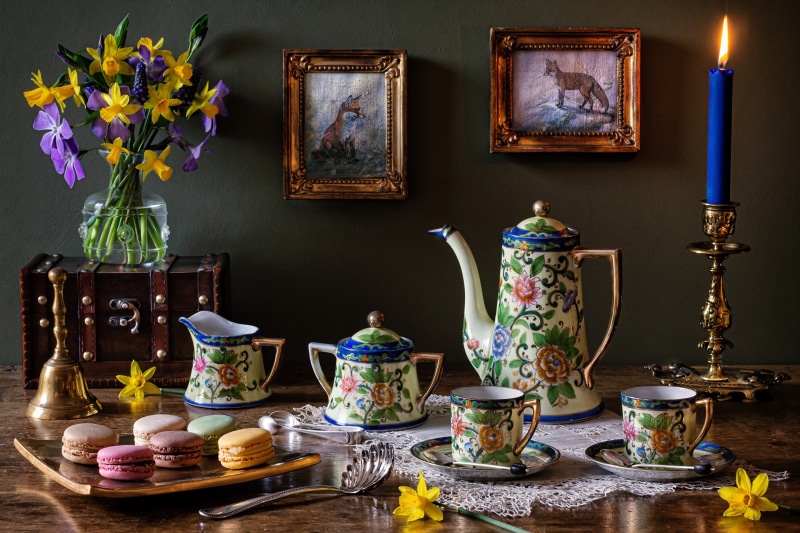 Still-life with tea set, macarons, and flowers