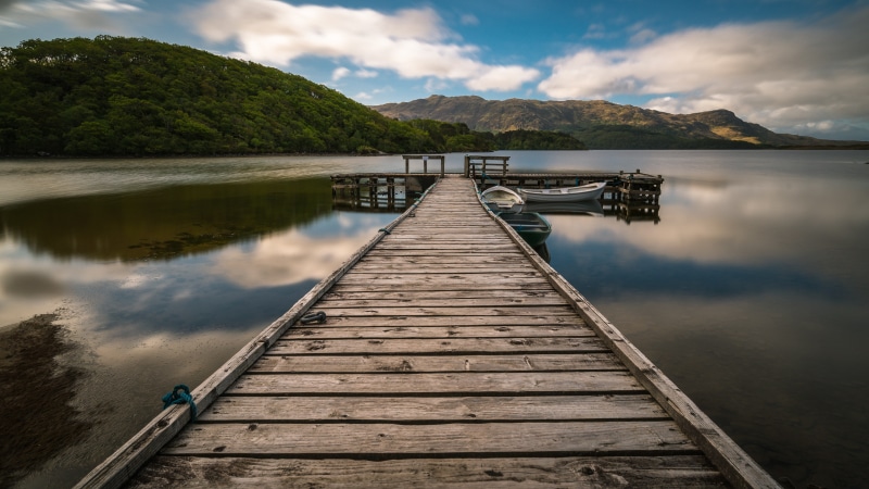 Wooden pier on Loch Morar with boats and mountains
