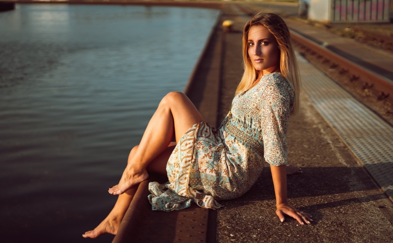 Woman in a dress sitting by the water