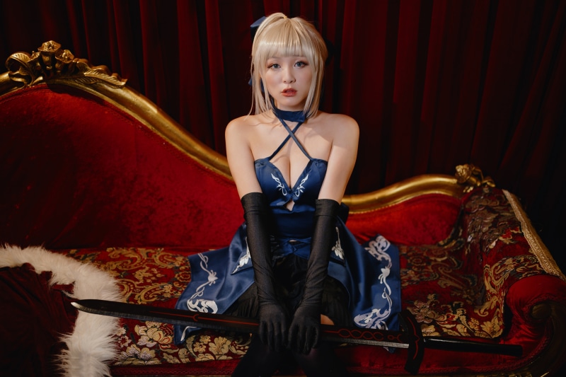 Blonde girl in blue dress with sword cosplay