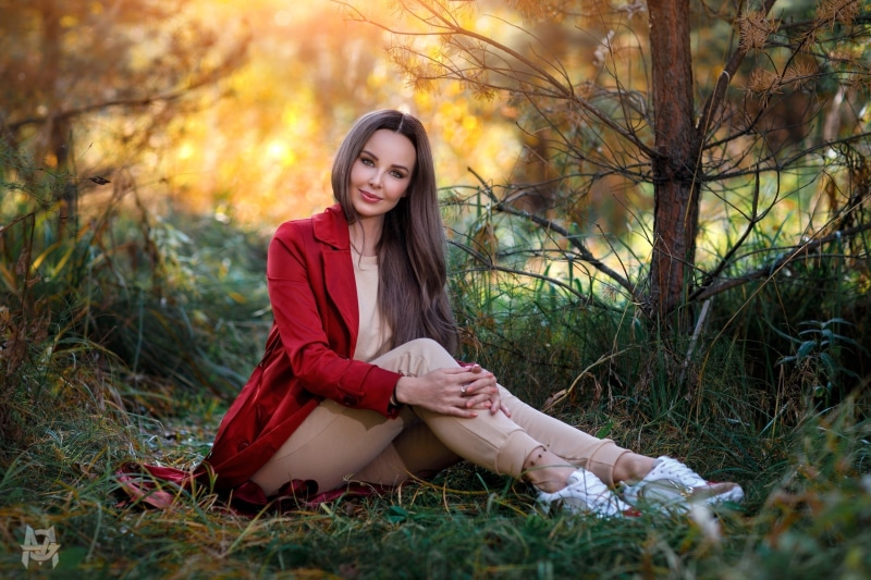 Woman in red coat sitting in grass