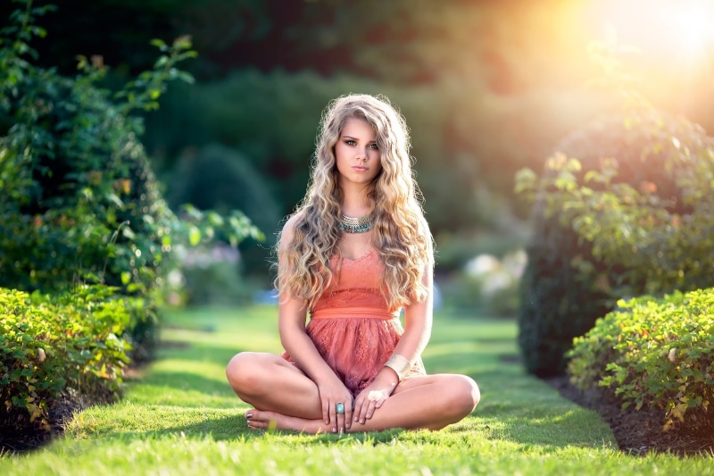 Blonde girl sitting in a garden