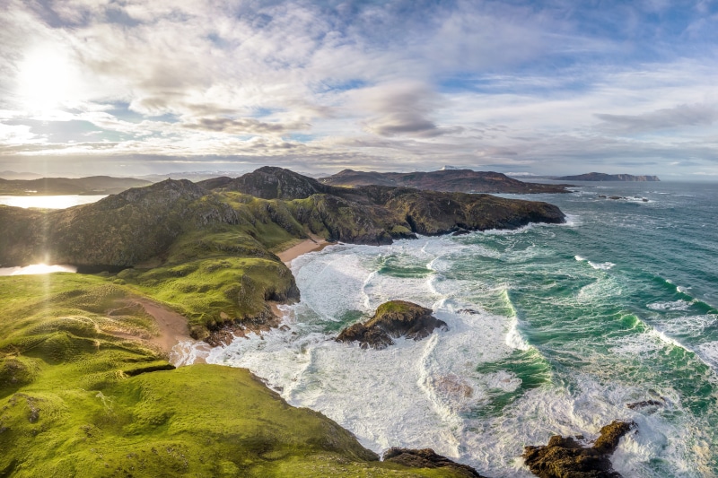 Rugged Irish Coastline with Crashing Waves and Mountains
