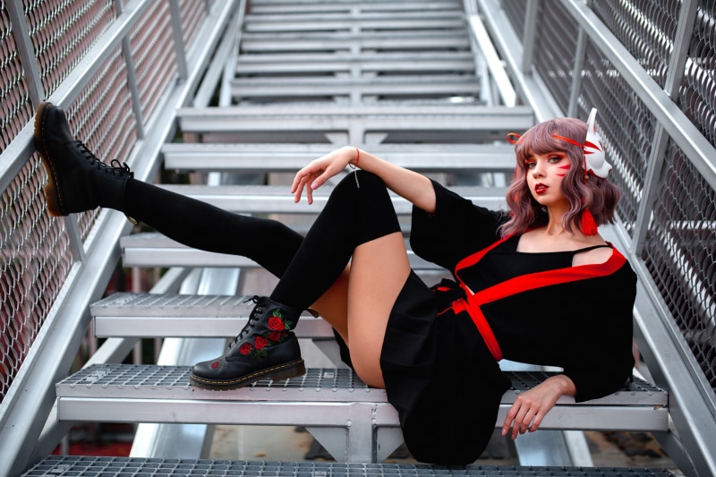 Woman in black and red cosplay outfit on stairs