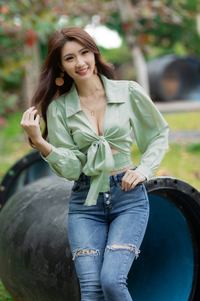 Asian woman in blouse and jeans smiling