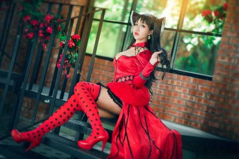 Asian woman in red cosplay outfit with stockings and stilettos