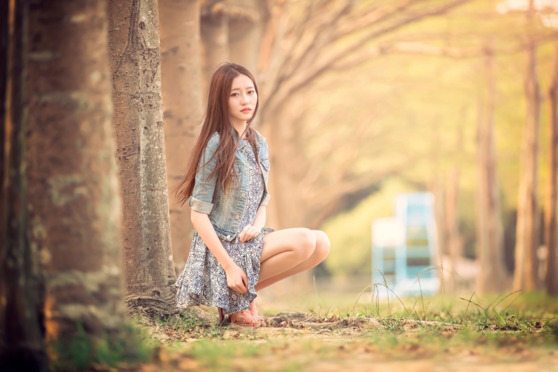Asian woman with brown hair wearing a dress and jacket