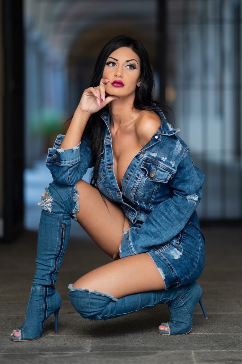 Brunette woman in denim outfit posing