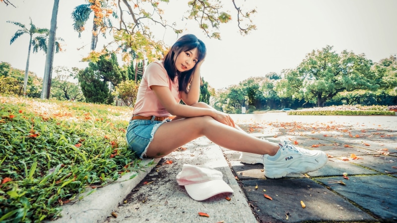 Asian girl in shorts sitting in a park
