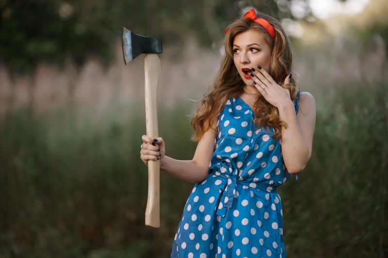 Woman in polka dot dress holding an axe