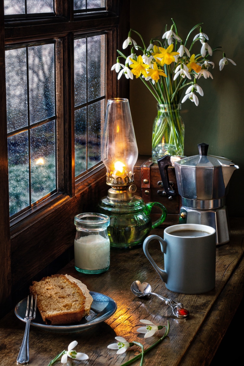 Still-life with daffodils, snowdrops, coffee, and cake
