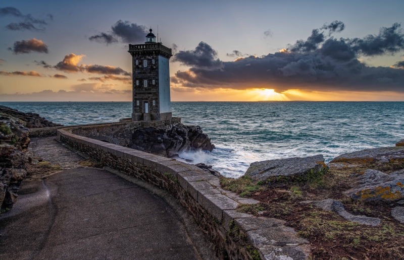 Lighthouse on the coast of Brittany, France at sunset