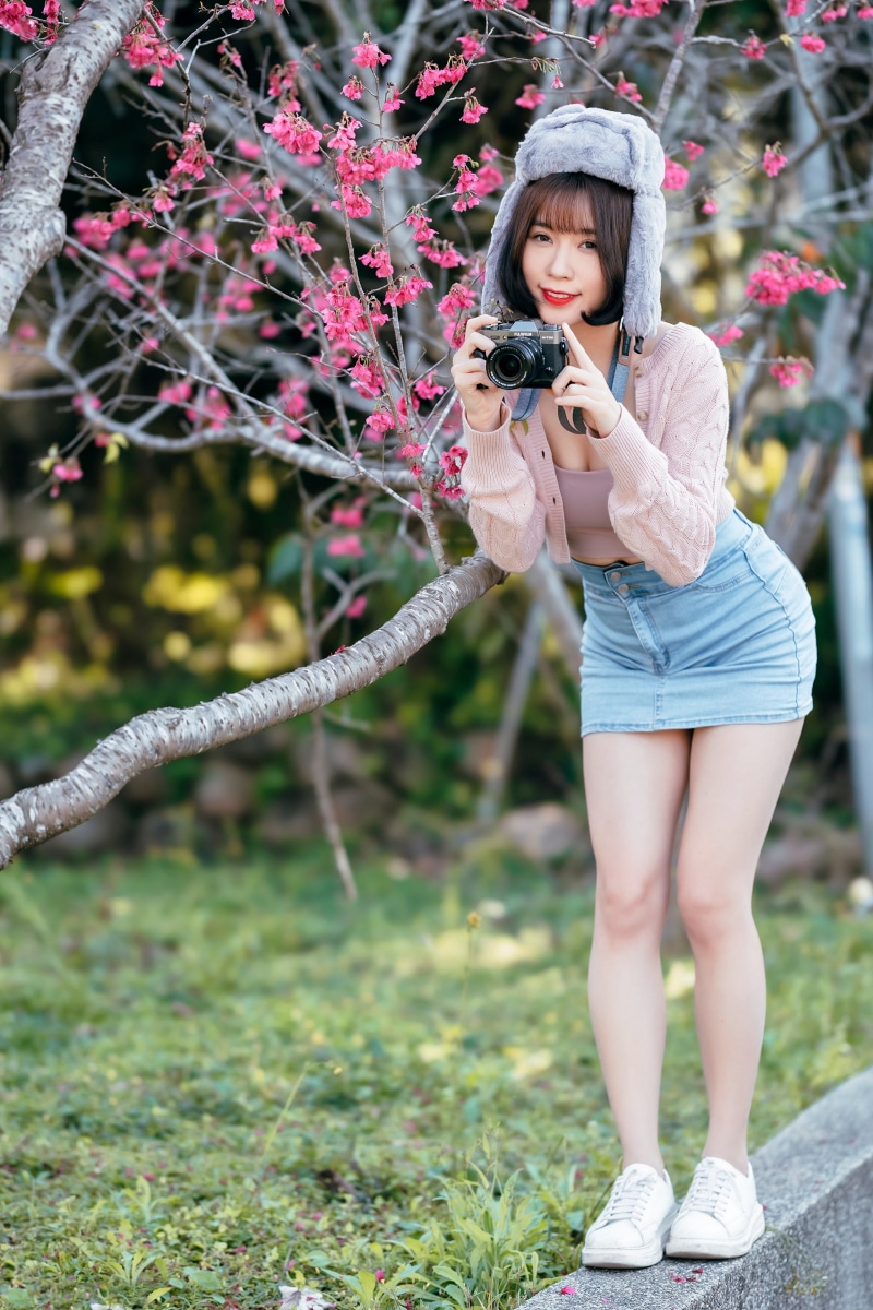 Asian woman in winter hat holding a camera
