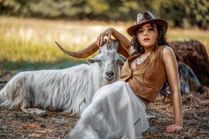 Woman in hat with goat