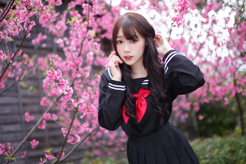 Asian schoolgirl in uniform with cherry blossoms