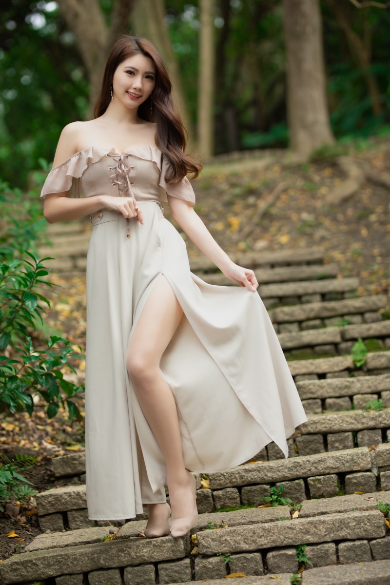Asian woman in a dress posing on stairs